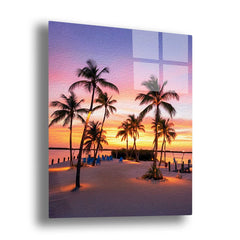 Glass wall art of a tropical sunset scene with palm trees on a beach.