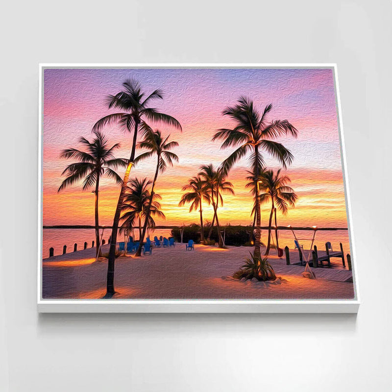 Framed artwork of a tropical sunset with palm trees and lounge chairs.
